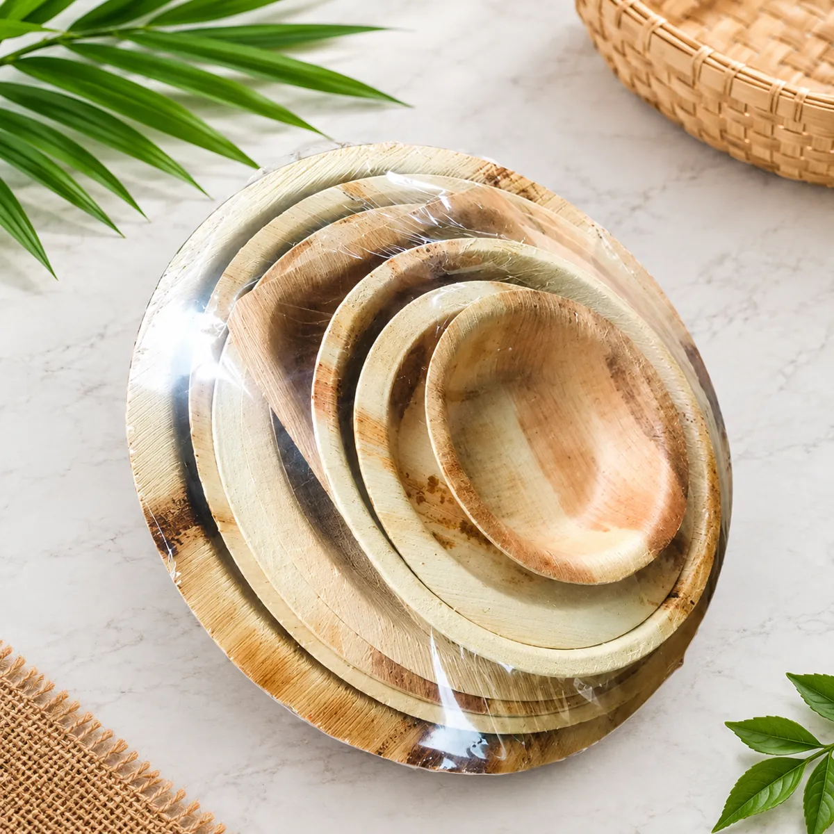 Stack of round areca palm leaf plates in different sizes, compostable and plastic free